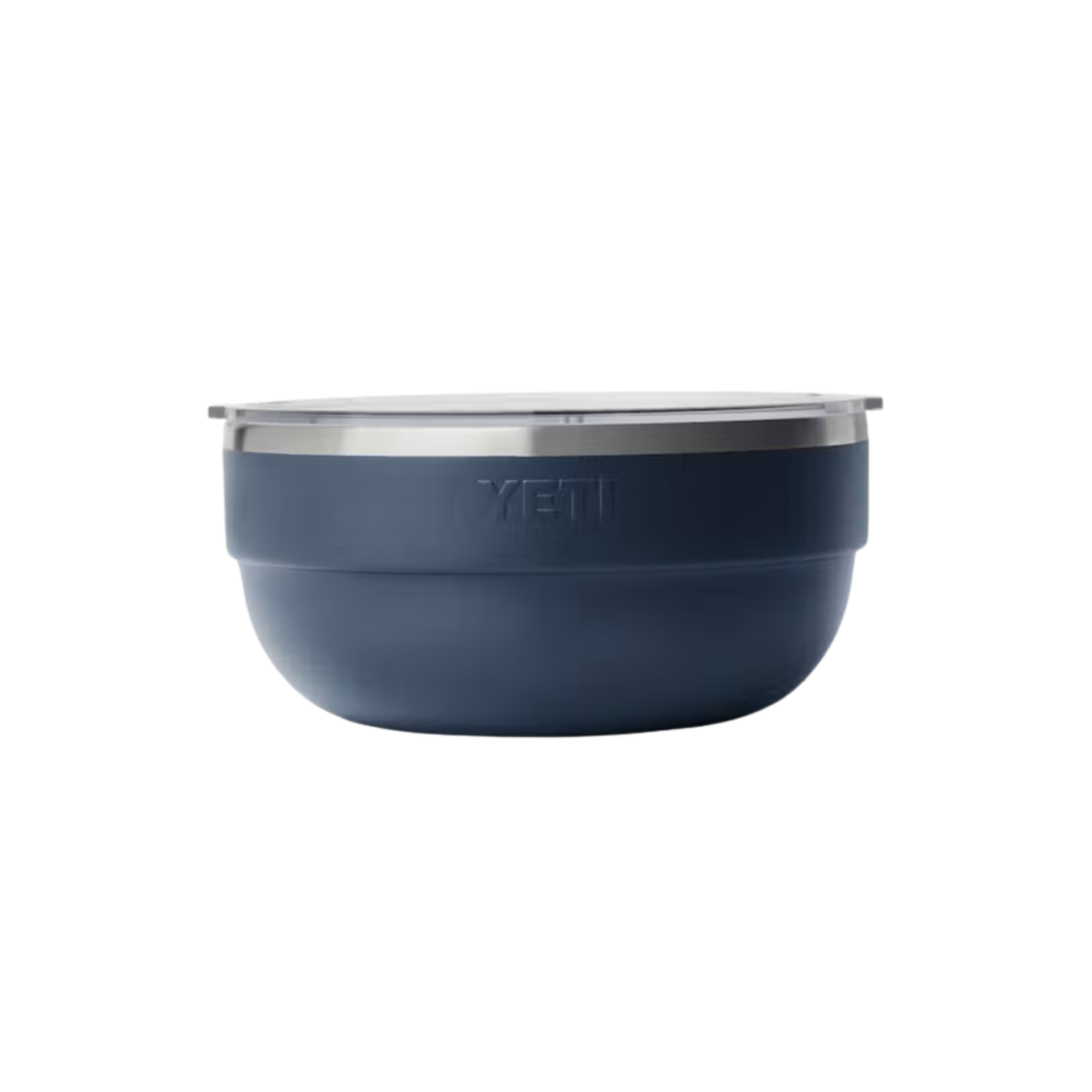 A YETI insulated bowl in a dark slate blue color with a brushed stainless steel rim and a matching lid, shown against a plain white background.