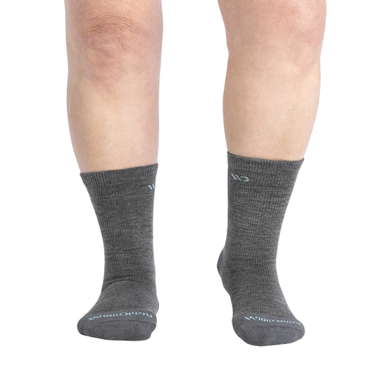 A pair of dark gray crew socks worn on a person's legs, shown from the calves down against a plain white background.