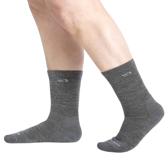 A pair of dark gray crew socks worn on a person's feet, shown against a plain white background.