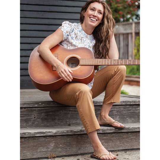 Old Ranch Women's Reagan Pull On Crop Pant - Dijon on a female model holding a guitar sitting on wooden steps.