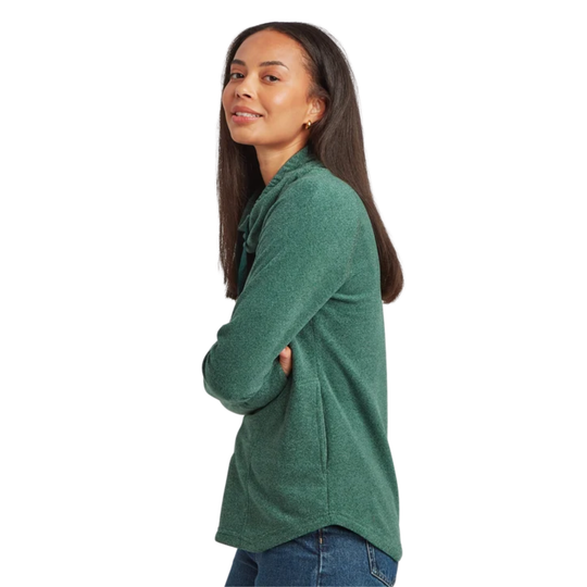 A woman with long dark hair is shown in profile wearing a heathered green long-sleeve top and blue jeans against a plain white background.