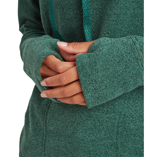 Close-up of a person wearing a textured green hoodie, showing the hands folded over the front pocket area, with a white background.