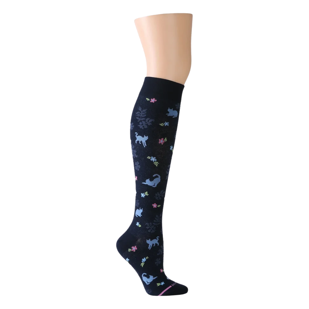 Navy knee-high sock with colorful animal pattern on a mannequin leg against a white background