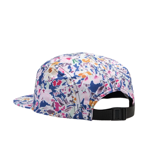 A flat-brim cap with a dense multicolor floral and abstract print on a white base, featuring a black adjustable snapback closure at the back.