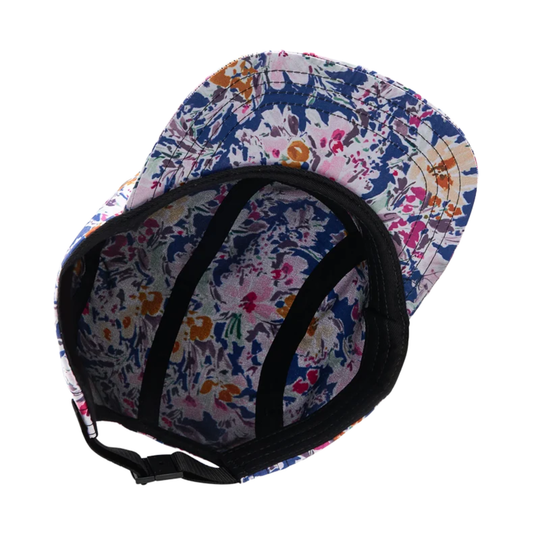 The underside of a baseball cap with a navy blue floral pattern, black ventilation straps, and an adjustable black chin strap, shown on a white background.