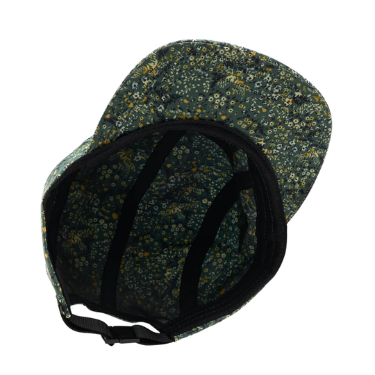A close-up of the inside of a baseball cap with a dark green floral pattern, black adjustable strap, and black trim, shown on a plain white background.