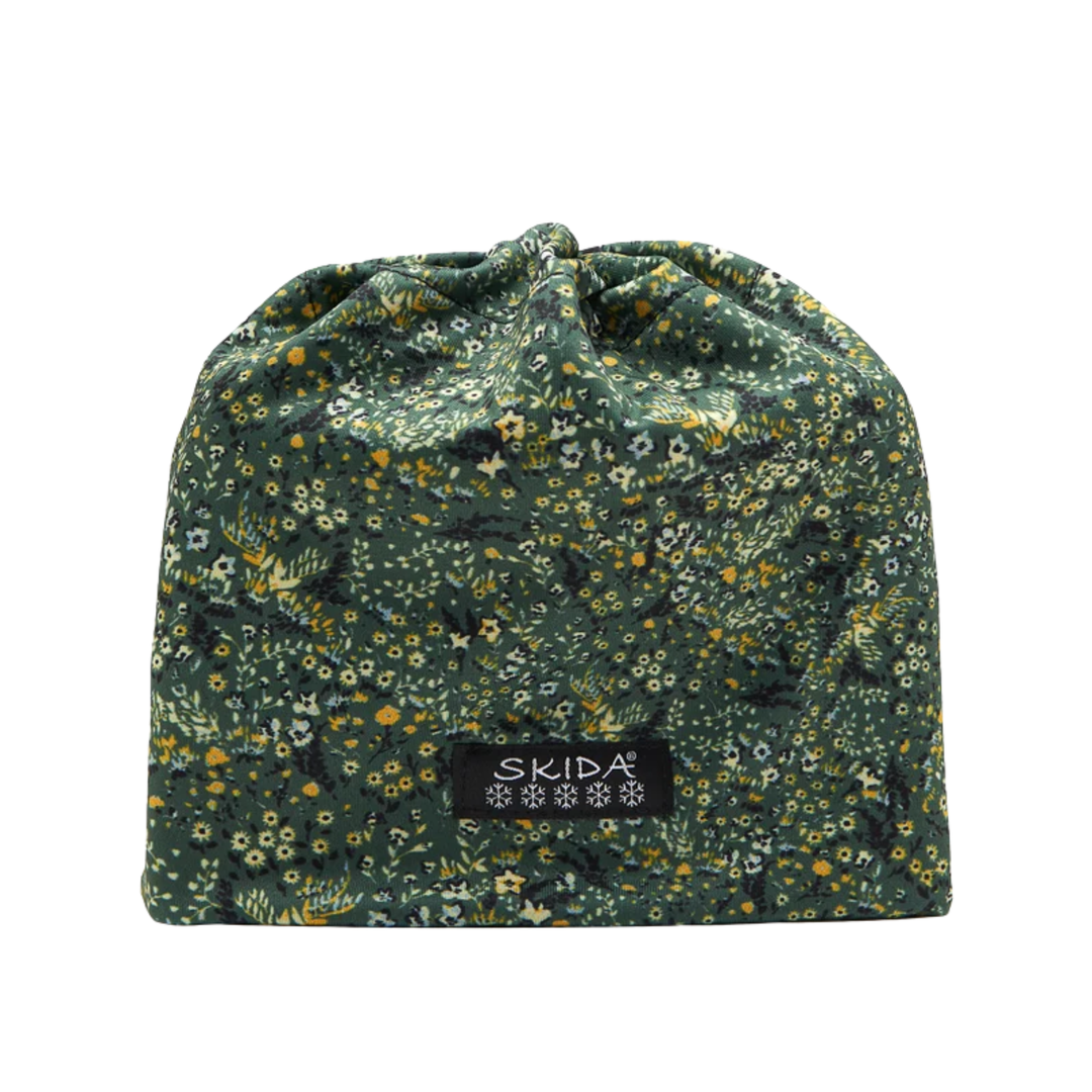 A drawstring pouch in a dark green floral fabric with small yellow, white, and orange flowers, featuring a black brand label that reads 'SKIDA' on a plain white background.