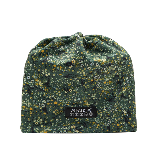 A drawstring pouch in a dark green floral fabric with small yellow, white, and orange flowers, featuring a black brand label that reads 'SKIDA' on a plain white background.