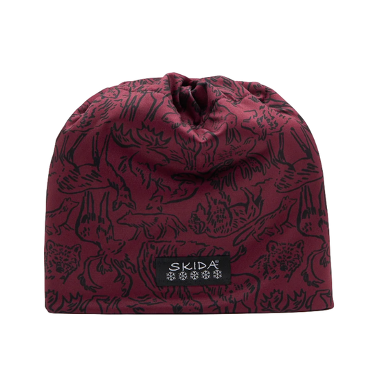 A drawstring beanie in burgundy with a black allover animal and mountain pattern, featuring a black rectangular patch with a white mountain logo on the front.