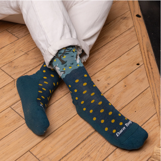 Darn Tough Vermont Women's Wild Life Lightweight Lifestyle Crew - Dark Teal on a wooden floor background.