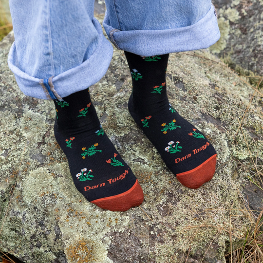 Darn Tough Vermont Women's Wildflower Crew Lightweight Lifestyle Sock - Black on a rock background