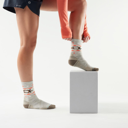 Person wearing patterned socks on a white background