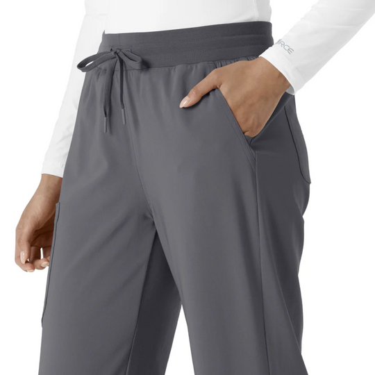 Gray boot-cut scrub pants with drawstring waistband and side pocket, shown on a model