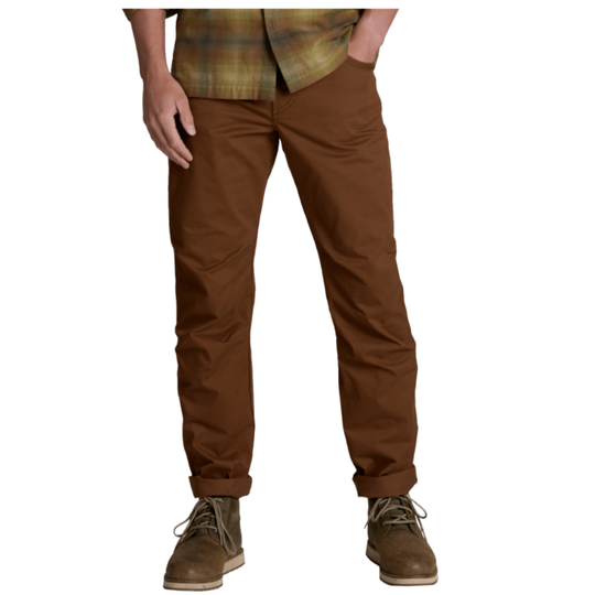 A person wearing brown straight-leg pants with a plaid shirt and brown lace-up boots, shown from the waist down on a plain white background.