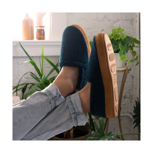 Navy fuzzy slip-on slippers with tan rubber soles, worn with light jeans