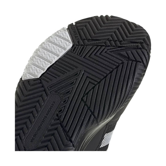 Black athletic shoe outsole with herringbone tread and a white traction patch