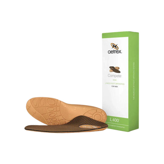 Pair of orthotic insoles with a tan molded top side and dark mesh underside beside a green and white Aetrex box
