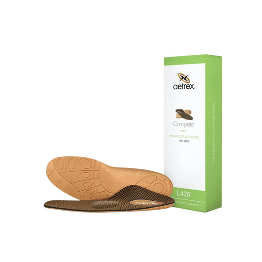 Orthotic insoles with tan footbed and black mesh top, shown with a green Aetrex box
