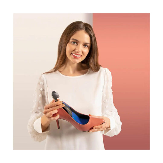 Woman holding a blush pink pointed-toe stiletto pump with a blue insole