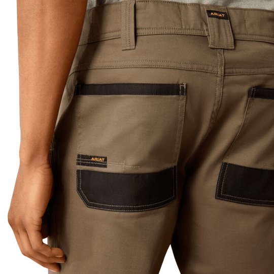 Rear view close-up of olive-brown cargo pants with black patch pockets and ARIAT labels