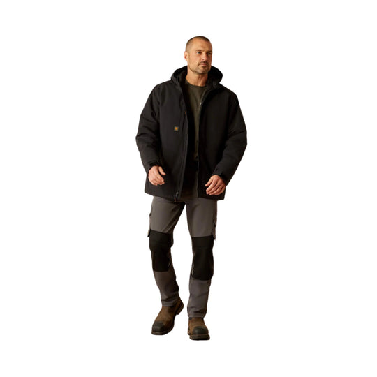 Black insulated hooded jacket worn over cargo pants and work boots