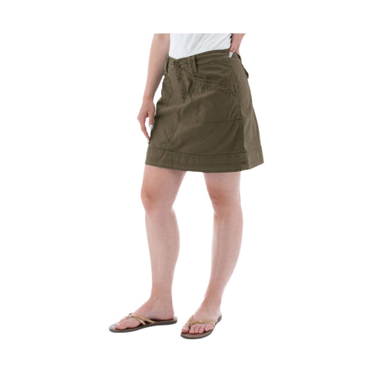 Olive green wrap-style skort with front patch pocket and short hem, worn with a white top and sandals