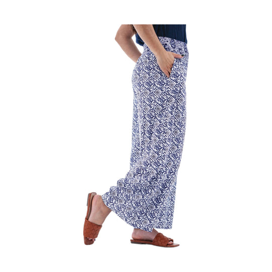 Model wearing blue-and-white patterned wide-leg palazzo pants with a smocked waistband and side pockets