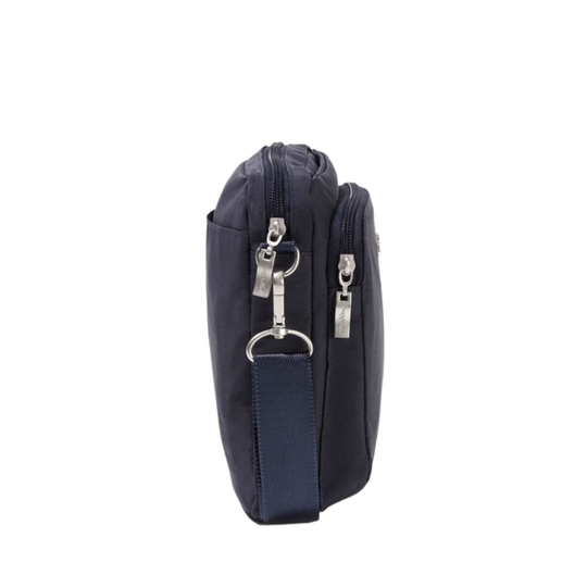 Navy crossbody bag shown in side view with two zip compartments and a shoulder strap