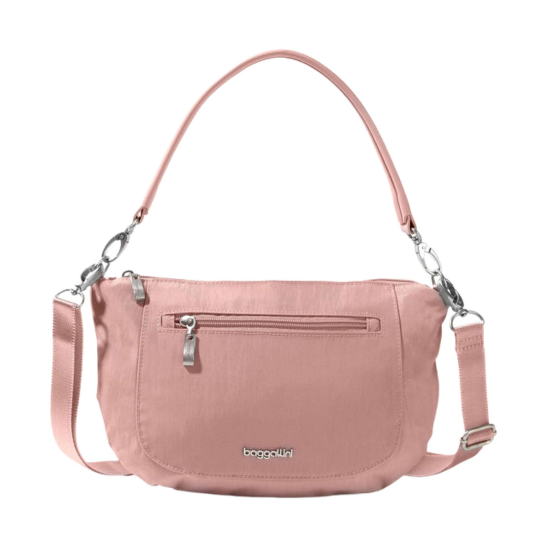 Pink crescent crossbody bag with top handle, silver hardware, front zip pocket, and adjustable strap