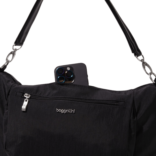 Black crescent-shaped crossbody bag with front zip pocket and adjustable strap