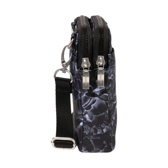 Small black crossbody bag with a marbled floral pattern, two front zip compartments, and an adjustable strap