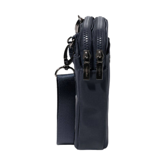 Navy crossbody bag shown from the side with two front zippers and a detachable wrist strap