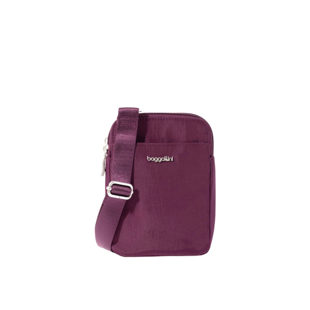Purple crossbody bag with front zip pocket, adjustable strap, and Baggallini logo