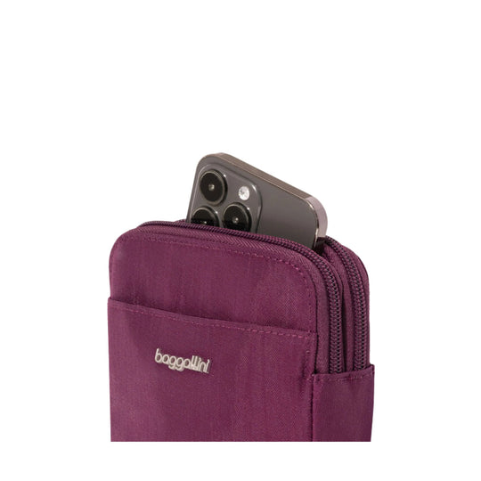 Plum crossbody pouch with dual zippers holding a smartphone