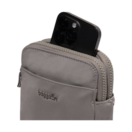 Gray zippered crossbody pouch with a smartphone partially inserted and a front slip pocket