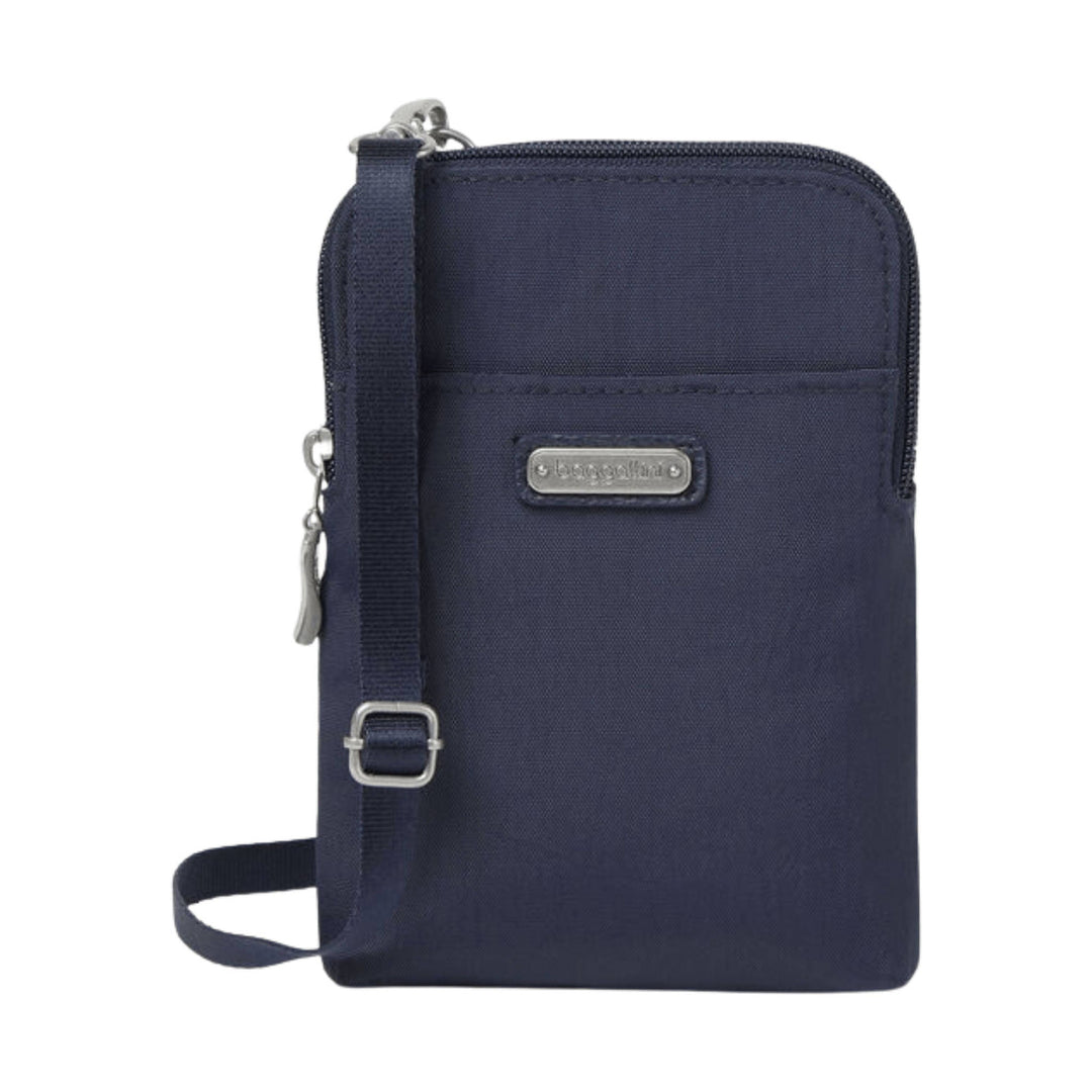 Navy zippered crossbody bag with front pocket, adjustable strap, and metal logo plate