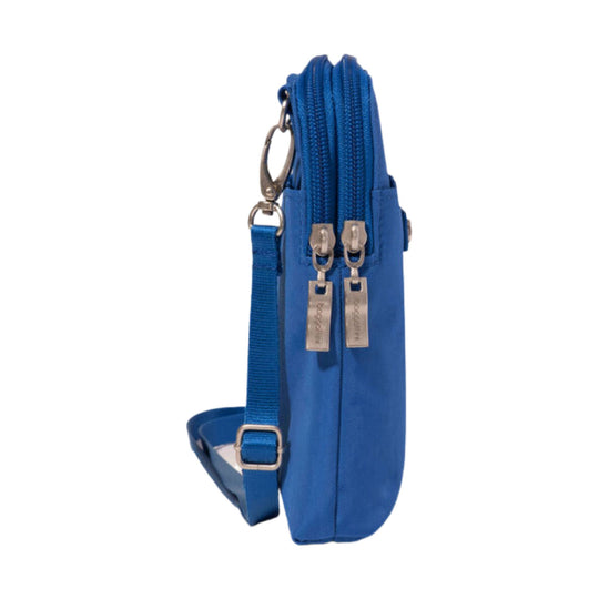 Blue crossbody bag shown in side profile with front zipper pockets, adjustable strap, and metal hardware