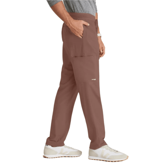 Brown straight-leg scrub pants with cargo pocket, shown on a model with white sneakers.