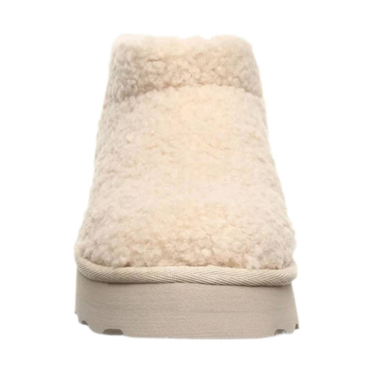 Cream fuzzy pull-on boot with a thick beige sole and rope trim at the opening