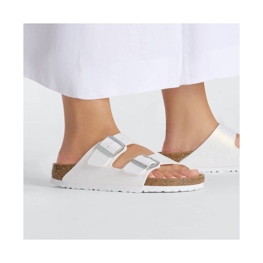 White double-strap sandal with cork footbed and silver buckles, side view on a model