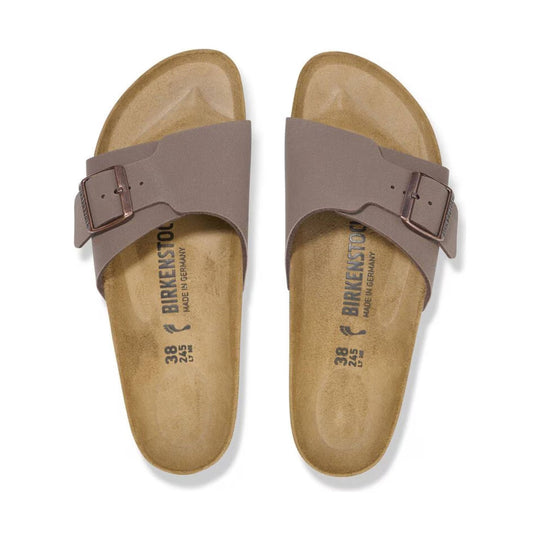 Pair of taupe slide sandals with wide buckled straps and contoured cork footbeds