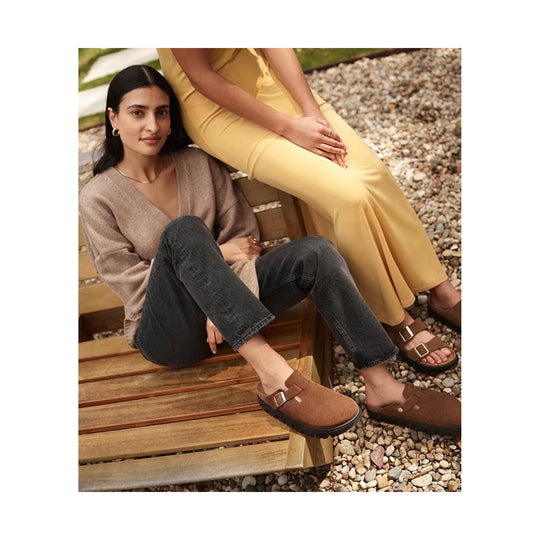 Brown clog-style slip-on shoes with buckle straps and black soles