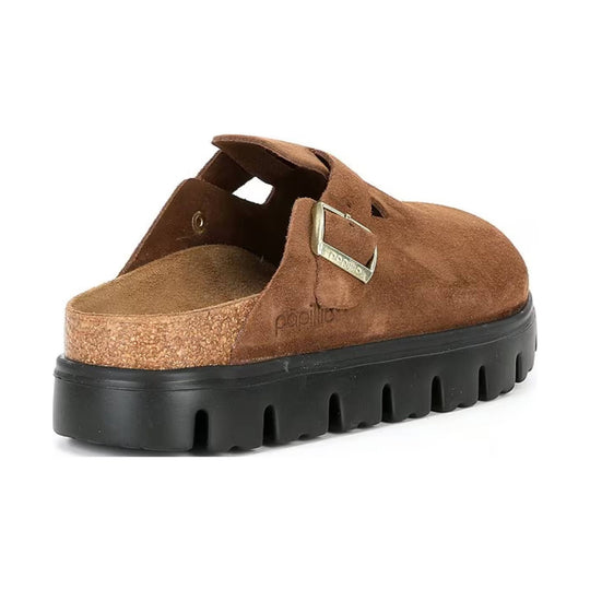 Brown suede platform clog with an oversized black lug sole and metal buckle