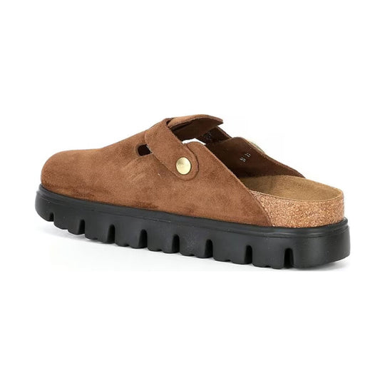 Brown suede slip-on clog with a black lug sole and brass side button