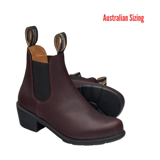 Pair of dark brown leather Chelsea boots with black elastic side panels and pull tabs, one boot showing the sole