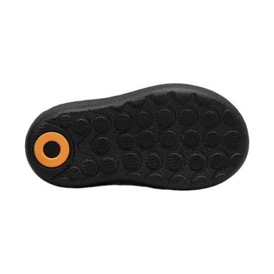 Black textured boot outsole with an orange circular accent