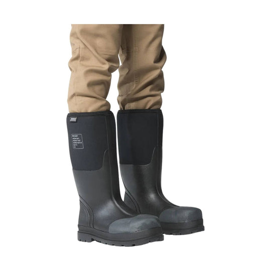 Black rubber boots worn with beige pants on a white background