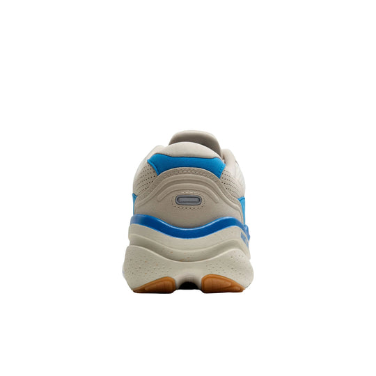 Rear view of a beige and blue running shoe with a thick white sole and orange tread
