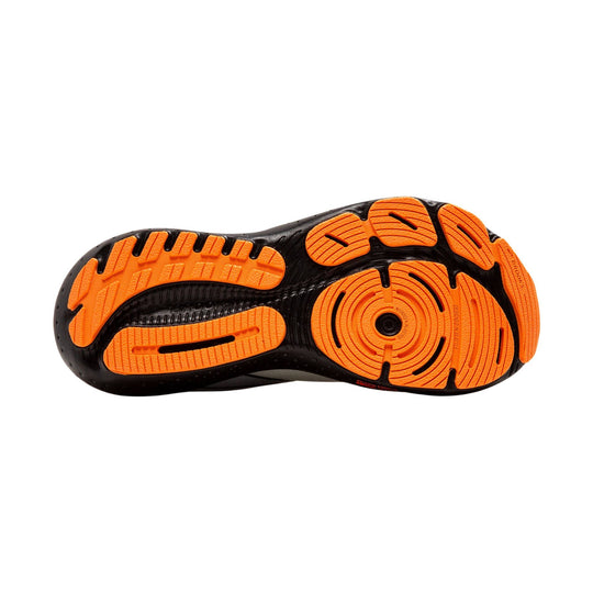 Black running shoe outsole with bright orange tread pods and circular forefoot grip pattern