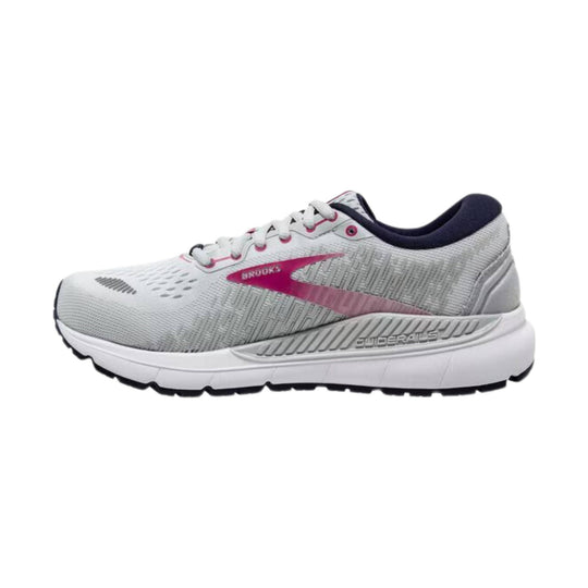 White running shoe with pink Brooks logo, navy collar, and black outsole, shown in side view.